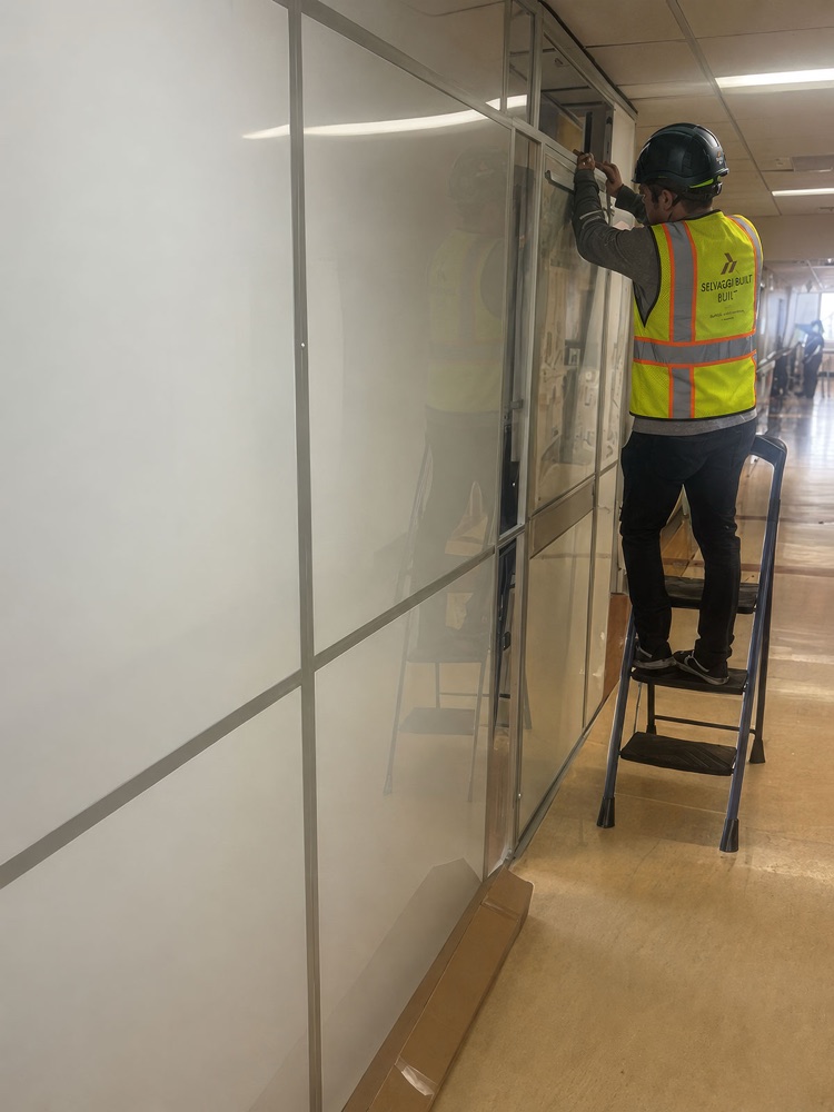 Selvaggi Built team member installing a containment barrier in an occupied hospital corridor