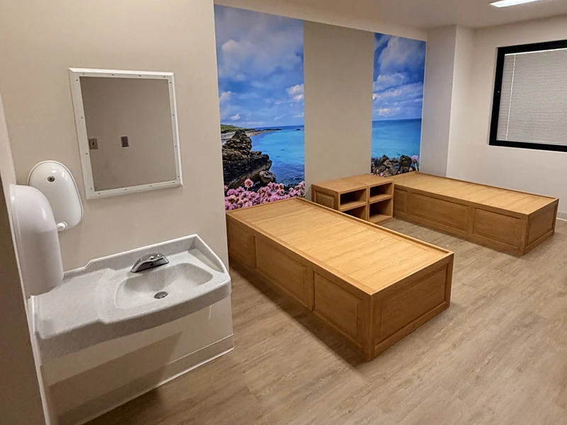 Anti-ligature behavioral health patient room with platform beds and therapeutic mural at Canyon Ridge