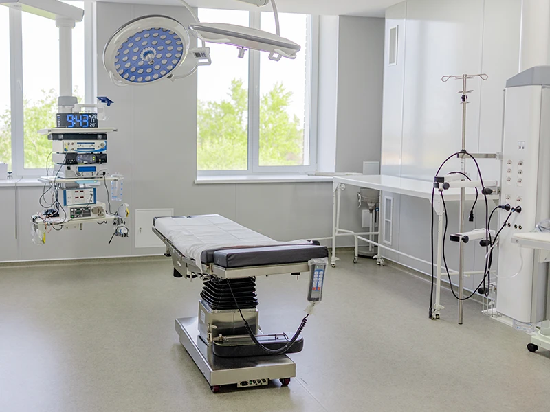 Clean outpatient surgery center operating room with surgical lighting, adjustable table, and natural light
